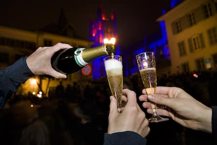 Des personnes boivent du champagne dans des coupes lors du passage de la nouvelle annee 2018 devant l'illumination de la Cathedrale de Lausanne durant la nuit du dimanche 31 decembre 2017 au lundi 1 janvier 2018 a Lausanne. (KEYSTONE/Jean-Christophe Bott)